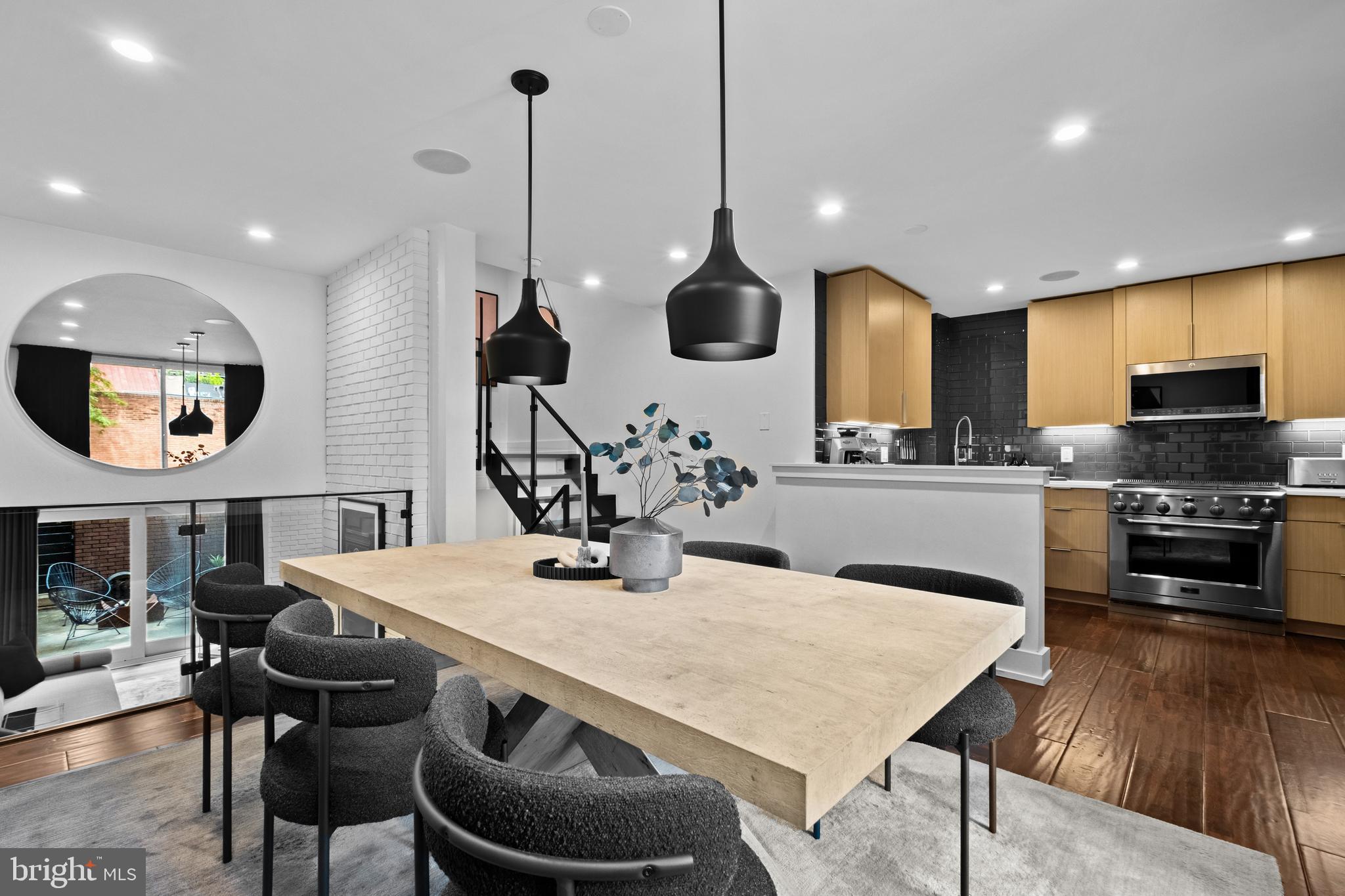 502 Delancey Street, Unit A Philadelphia, PA 19106 - Photo 8 of 32 a kitchen with stainless steel appliances granite countertop a stove a refrigerator a kitchen island a dining table and chairs