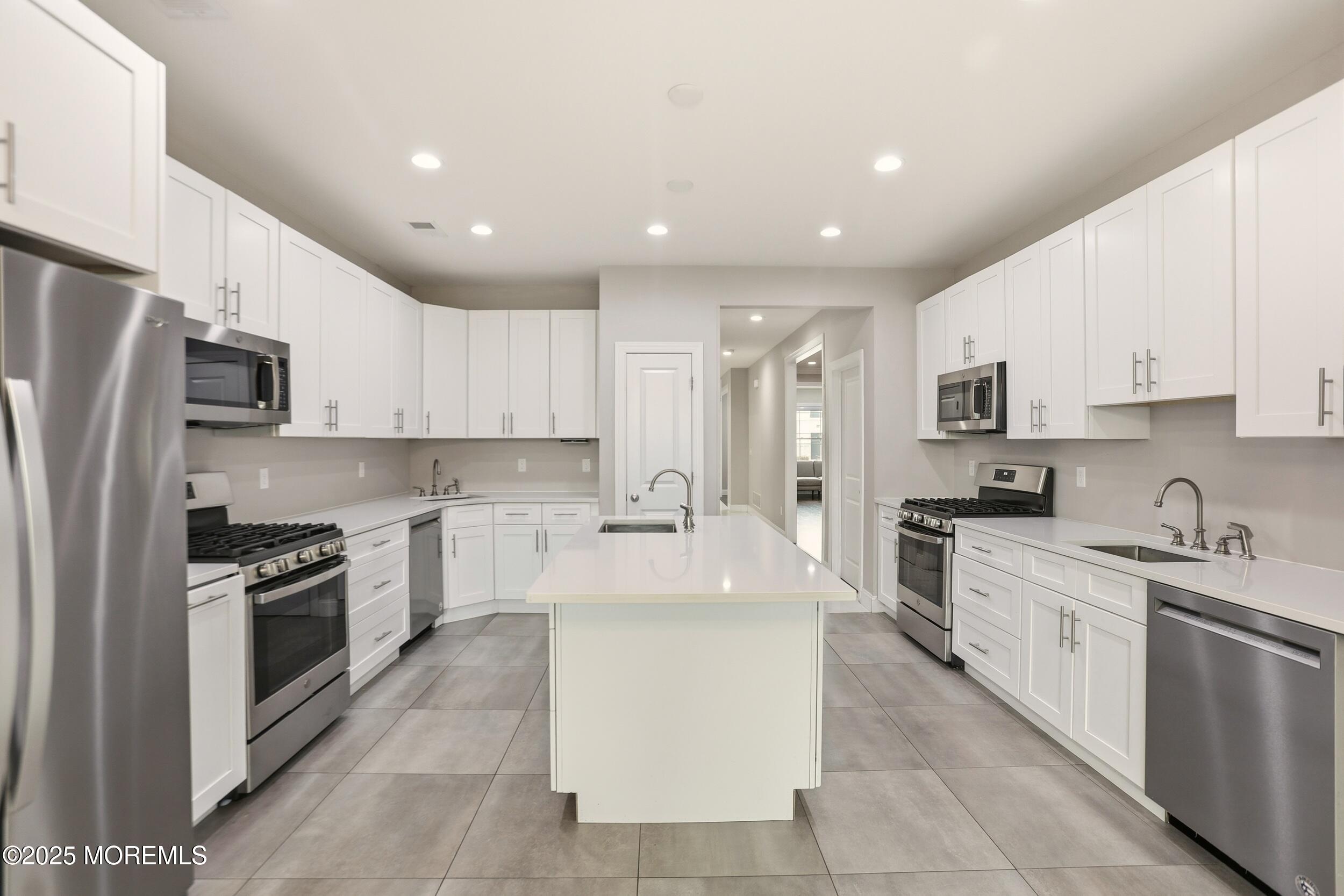 119 North Zinfandel Road Lakewood, NJ 08701 - Photo 11 of 29 a large kitchen with stainless steel appliances granite countertop a stove top oven a sink and cabinets