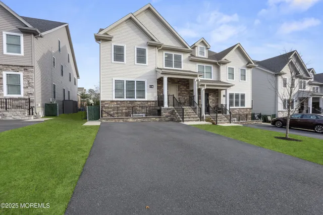 a view of a white house with a yard patio and a road