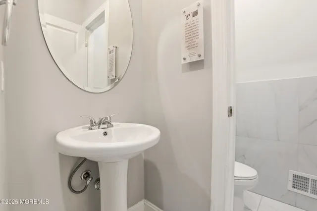 a bathroom with a sink a toilet and a mirror