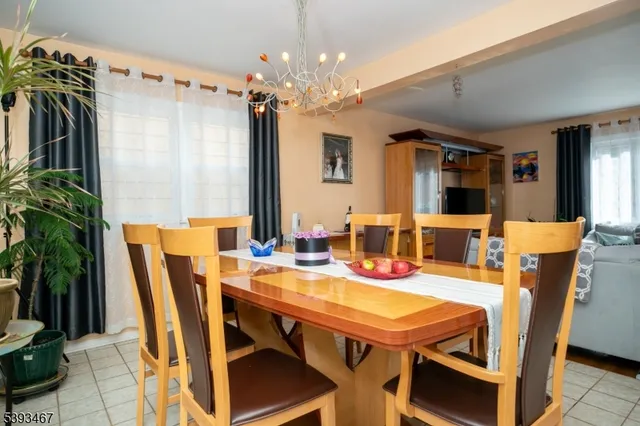 a kitchen with stainless steel appliances granite countertop a dining table chairs refrigerator and sink