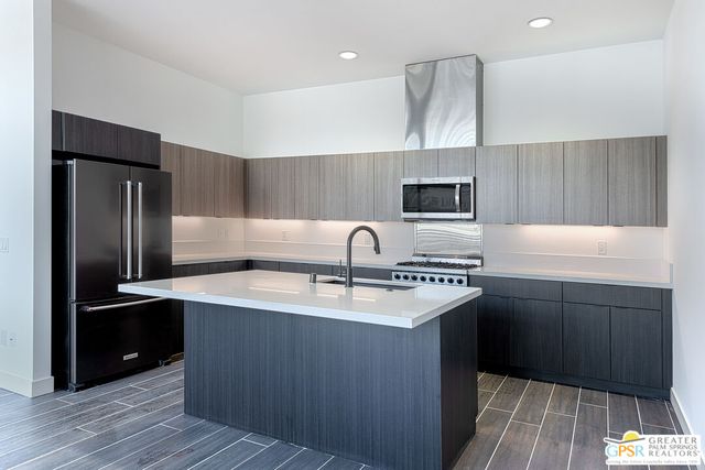 a large kitchen with stainless steel appliances granite countertop a stove a sink and a refrigerator