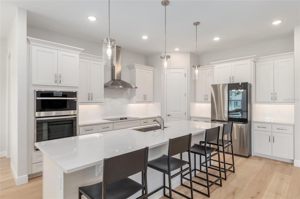 1929 Northwest 85th Loop Ocala, FL 34475 - Photo 15 of 55 a kitchen with stainless steel appliances kitchen island a table chairs refrigerator and sink