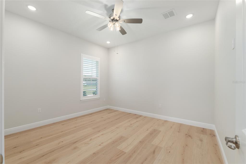 1929 Northwest 85th Loop Ocala, FL 34475 - Photo 42 of 55 an empty room with wooden floor and windows