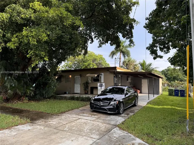 a car parked in front of a house and a small yard