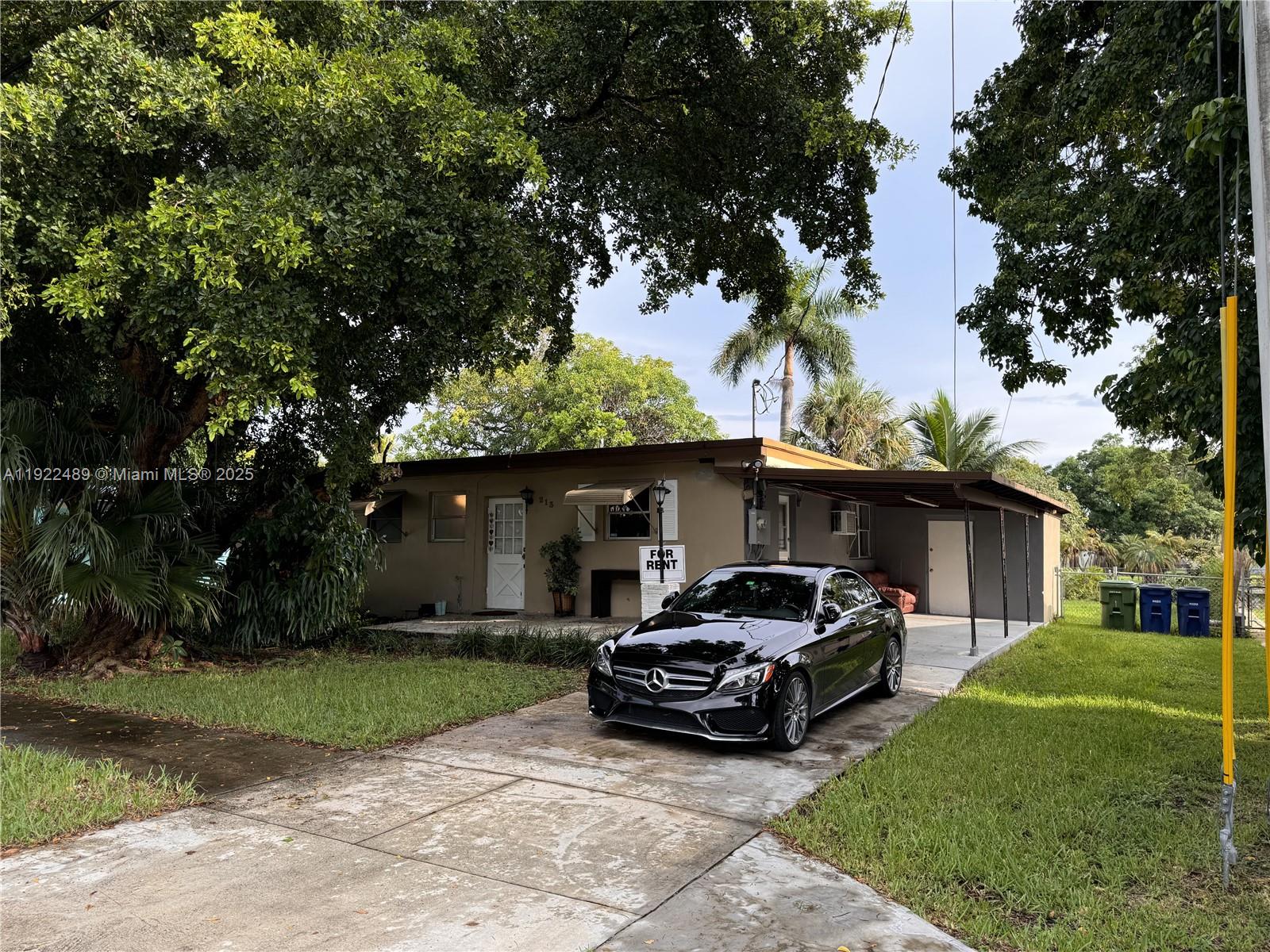 213 Southwest 5th Street Hallandale Beach, FL 33009 - Photo 2 of 17 a car parked in front of a house and a small yard