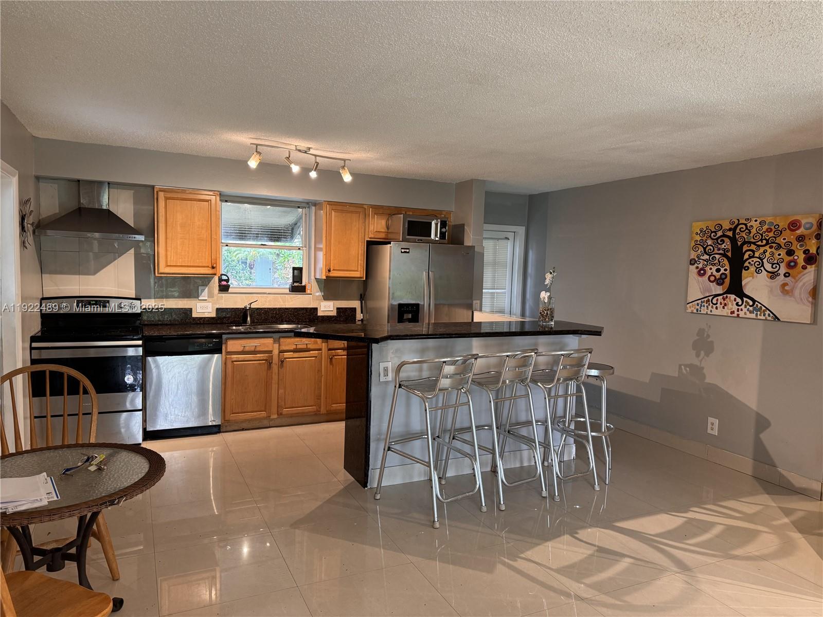 213 Southwest 5th Street Hallandale Beach, FL 33009 - Photo 3 of 17 a kitchen with a table and chairs in it