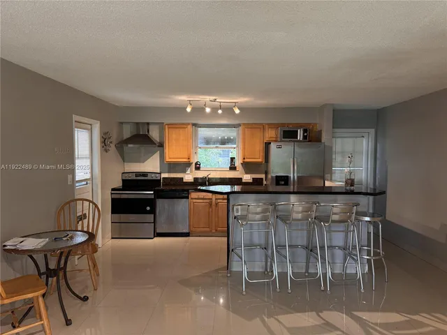 a kitchen with stainless steel appliances kitchen island granite countertop a sink and cabinets