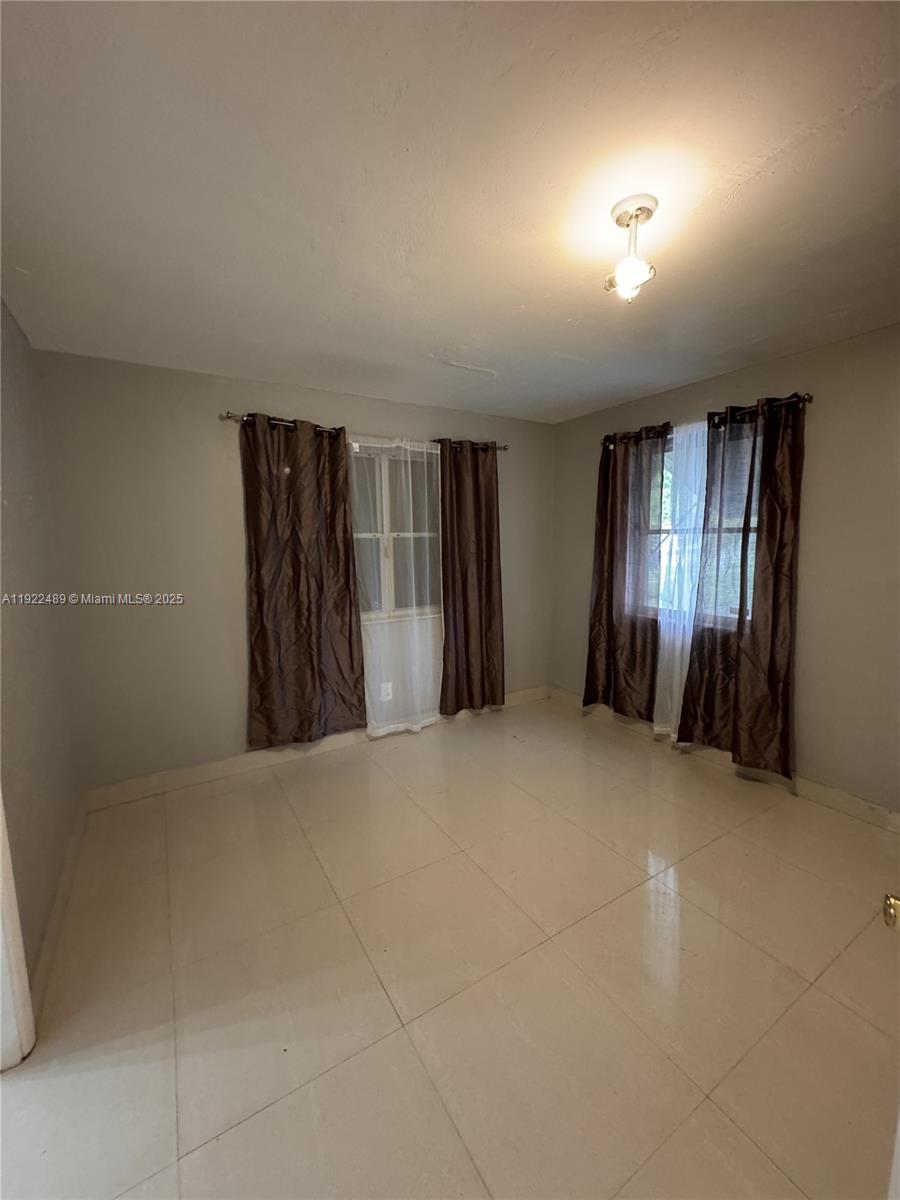 213 Southwest 5th Street Hallandale Beach, FL 33009 - Photo 10 of 17 an empty room with windows and closet