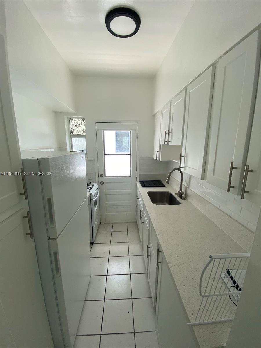 9056 Collins Avenue, Unit 23 Surfside, FL 33154 - Photo 6 of 12 a kitchen with stainless steel appliances a sink a stove a refrigerator a window