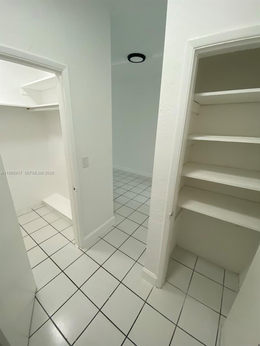 9056 Collins Avenue, Unit 23 Surfside, FL 33154 - Photo 7 of 12 a view of walk in closet with empty racks