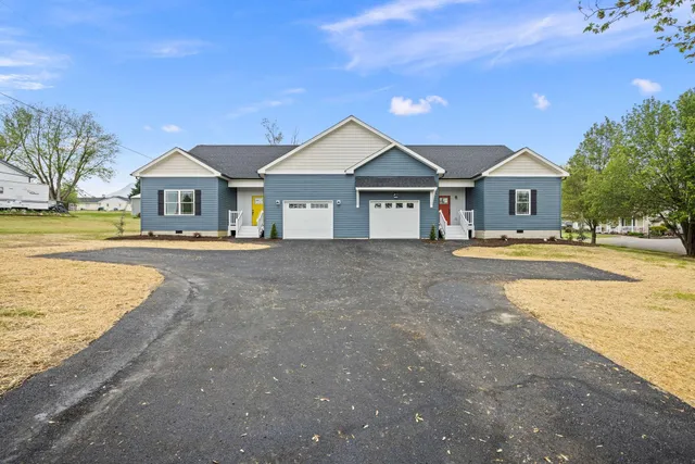 a front view of a house with a yard and lake view