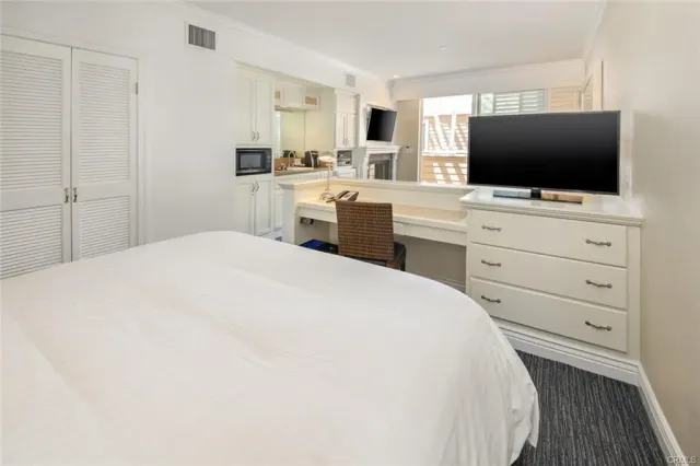 a bedroom with a flat screen tv and dresser