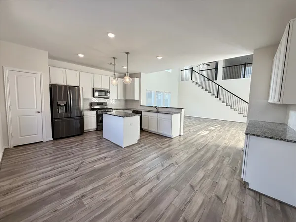 a kitchen with stainless steel appliances a refrigerator and a stove top oven