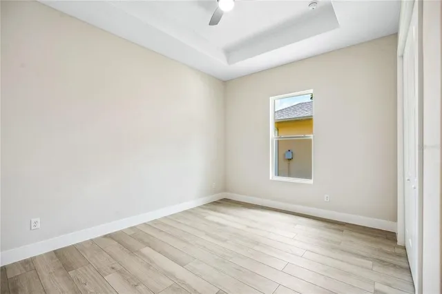 an empty room with a window and wooden floor