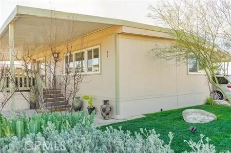 a backyard of a house with plants and a fountain