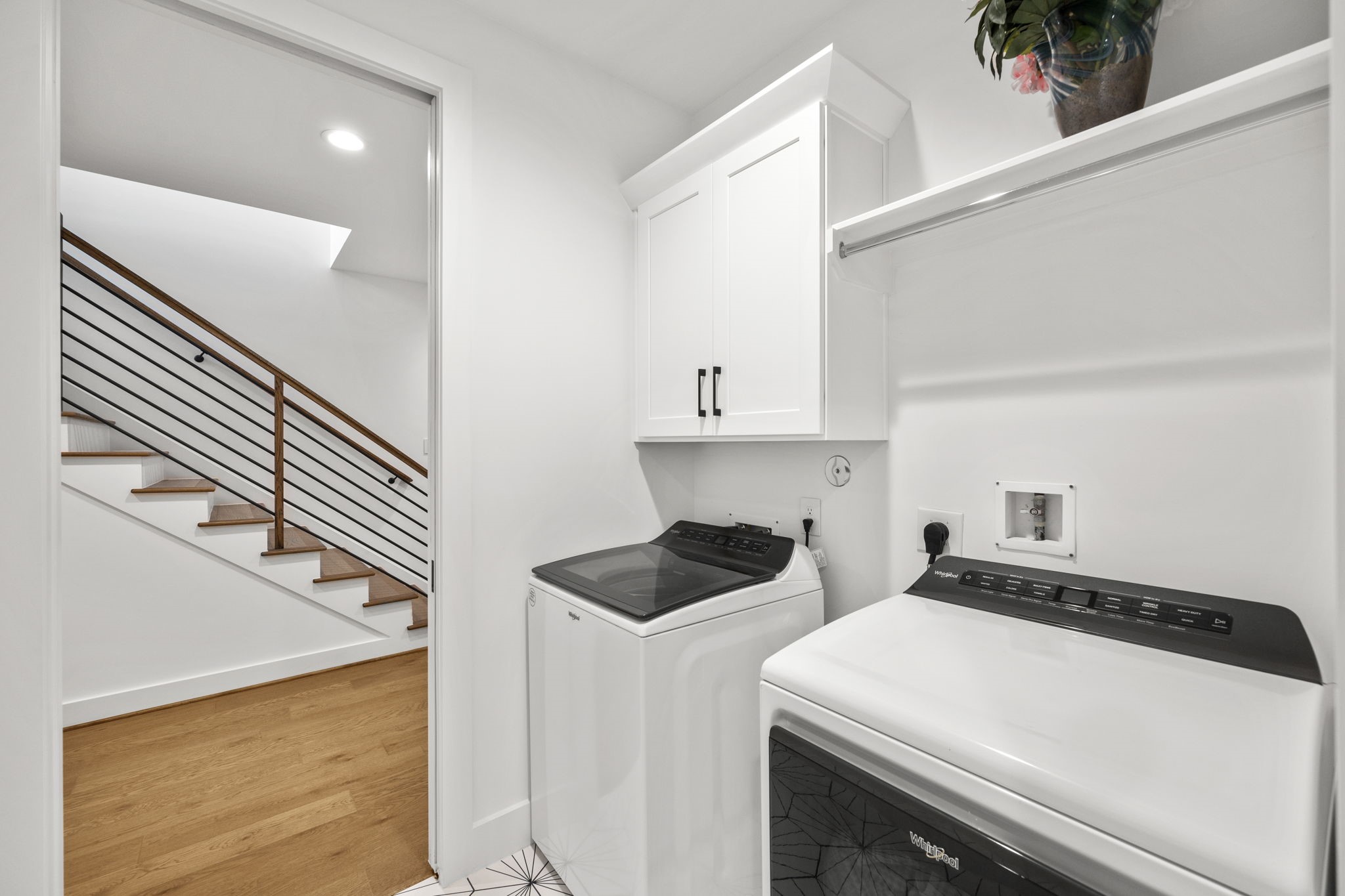 2411 Hazard Street Houston, TX 77019 - Photo 25 of 46 This second-floor laundry room offers convenience and efficiency with a spacious layout, including upper cabinetry for storage and a hanging rod for added functionality. The sleek design and easy access from the stairway make household chores a breeze in this well-appointed space.