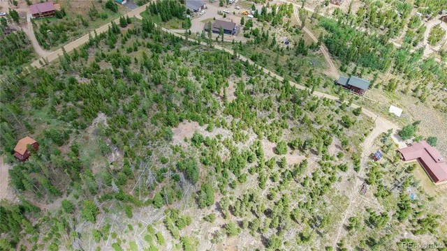 a view of a house with a lush green forest
