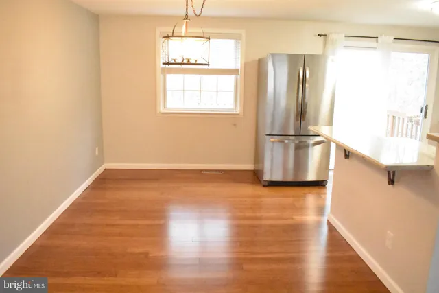 a view of a kitchen with wooden floor electronic appliances and windows