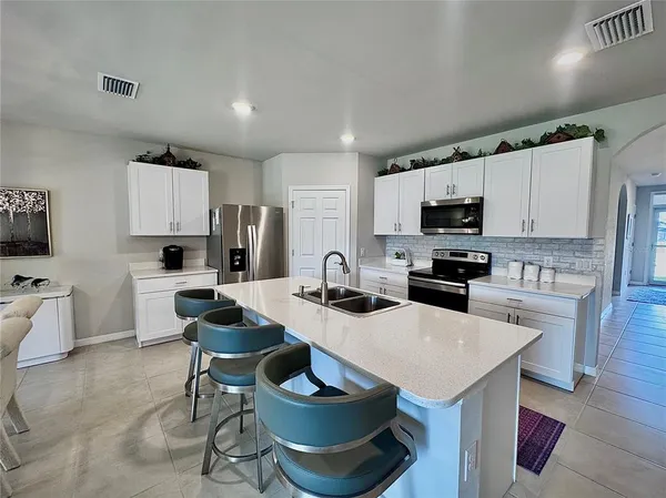 a kitchen with a sink a stove and chairs