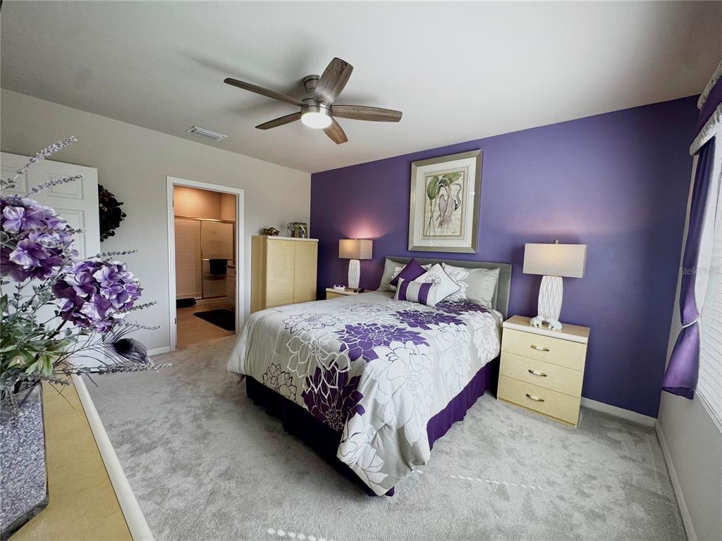 4077 Manatee Lane Punta Gorda, FL 33980 - Photo 17 of 35 a spacious bedroom with a bed and a chandelier