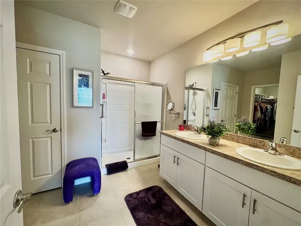a bathroom with a double vanity sink mirror and shower
