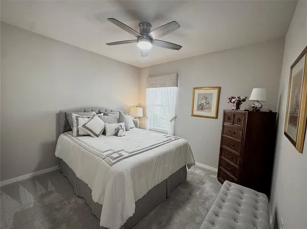 a bedroom with a large bed and a ceiling fan