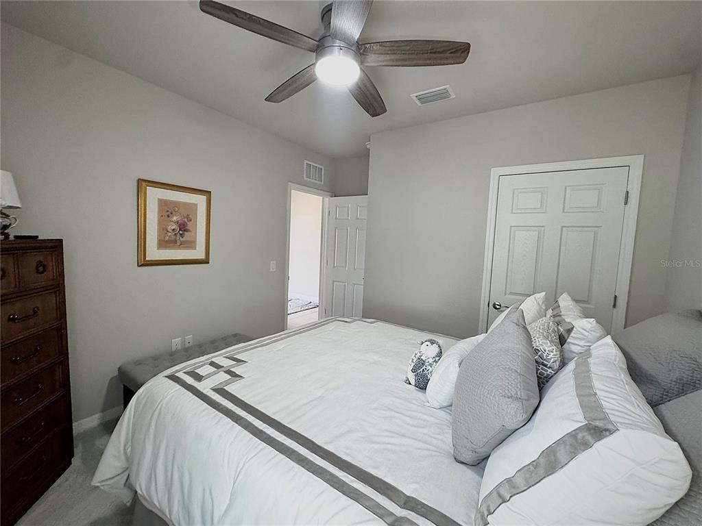 4077 Manatee Lane Punta Gorda, FL 33980 - Photo 24 of 35 a bedroom with a large bed and a ceiling fan