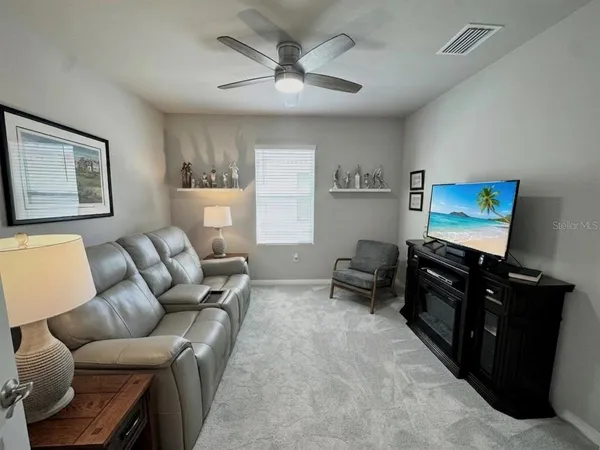 a living room with furniture a air conditioner vent and a window
