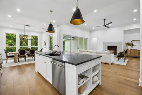 a kitchen with stainless steel appliances granite countertop a stove and a wooden floors