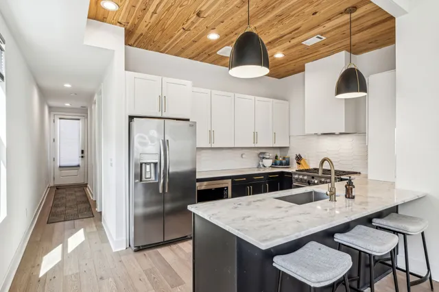 a kitchen with a table a refrigerator and cabinets