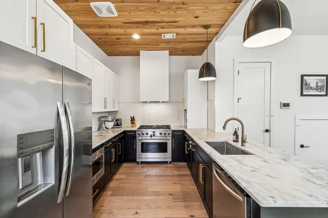 a kitchen with stainless steel appliances granite countertop a sink stove and refrigerator