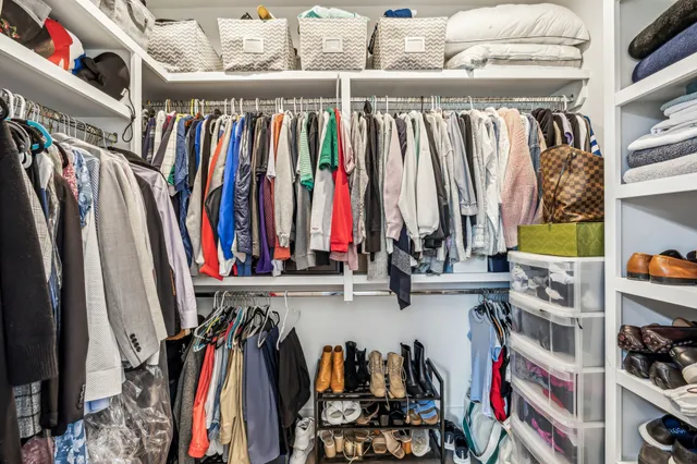 a view of walk in closet with clothes and shoes