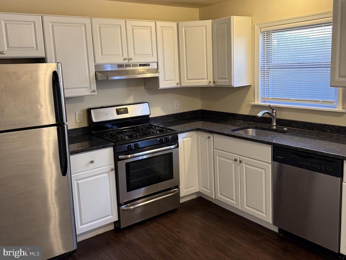 223 Gerritt Street Philadelphia, PA 19147 - Photo 3 of 10 a kitchen with granite countertop white cabinets and white appliances