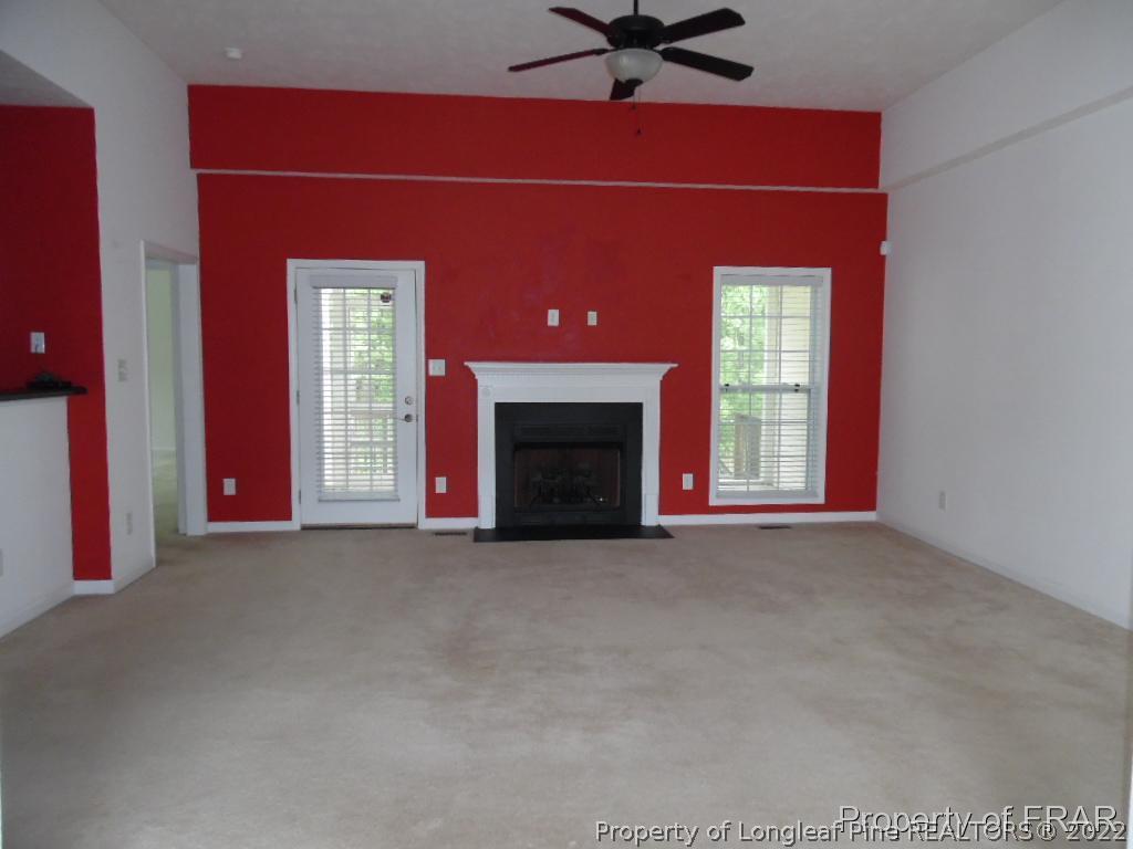76 Ithica Lane Bunnlevel, NC 28323 - Photo 5 of 35 an empty room with windows fireplace and a ceiling fan