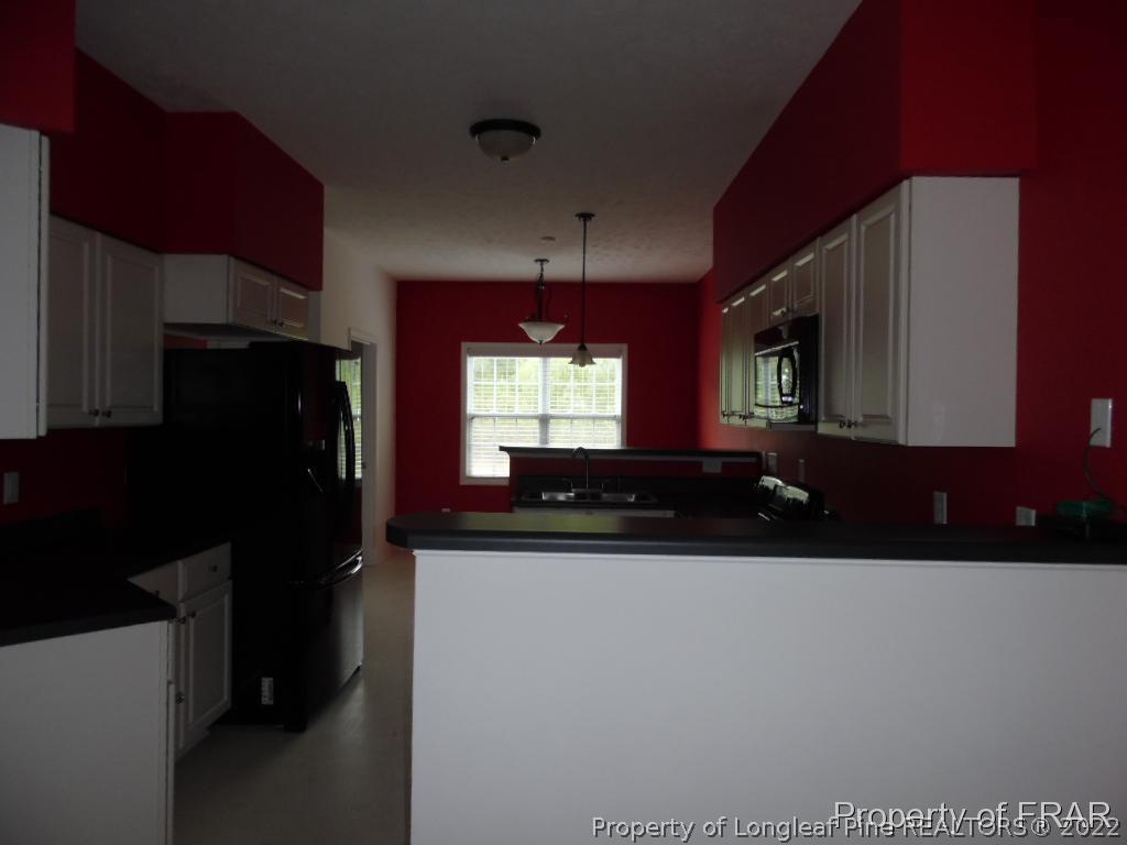76 Ithica Lane Bunnlevel, NC 28323 - Photo 7 of 35 a kitchen with a sink a refrigerator and a stove