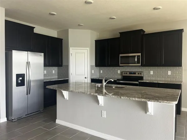 a kitchen with stainless steel appliances wooden cabinets a refrigerator and a sink