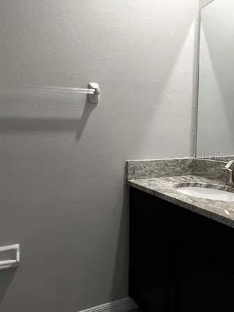 a bathroom with a granite countertop toilet sink and mirror