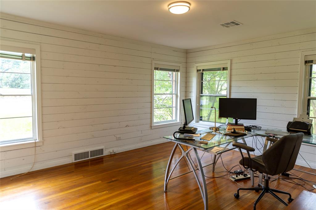 3228 Colcord Avenue Waco, TX 76707 - Photo 25 of 29 Room featuring wood-finish flooring, white shiplap walls, multiple windows, recessed lighting, and a ceiling-mounted light fixture
