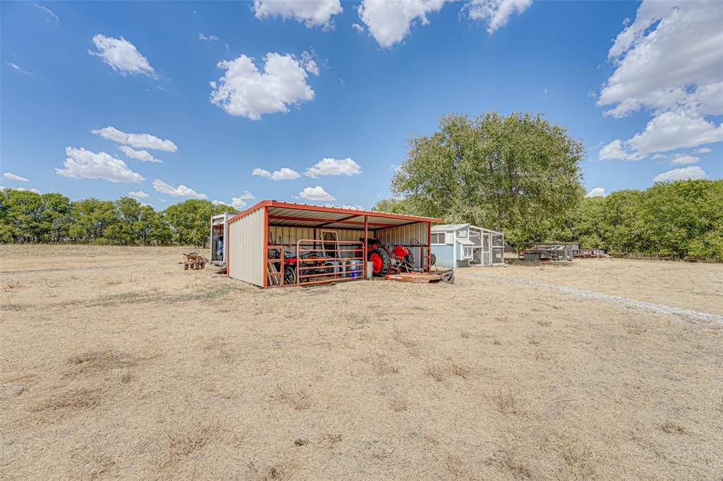 521 Bakers Branch Road Waxahachie, TX 75167 - Photo 4 of 37 Expansive open field featuring a multi-purpose metal shed, secondary outbuilding, and a gravel path