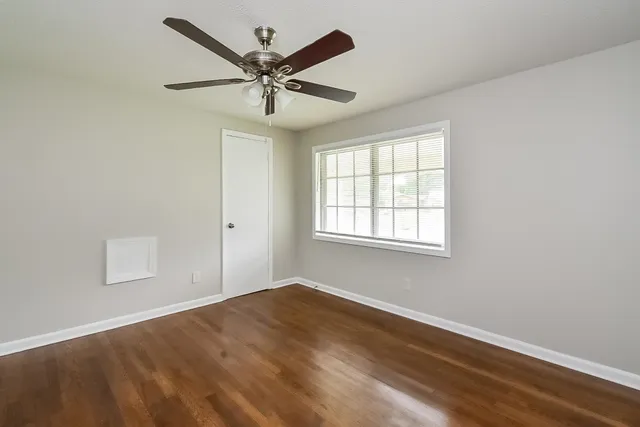 a view of a big room with wooden floor and windows in a room