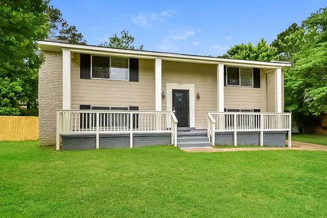 a backyard of a house with table and chairs