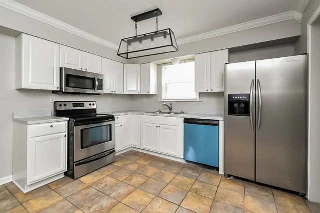 a kitchen with stainless steel appliances granite countertop a stove a sink and a refrigerator