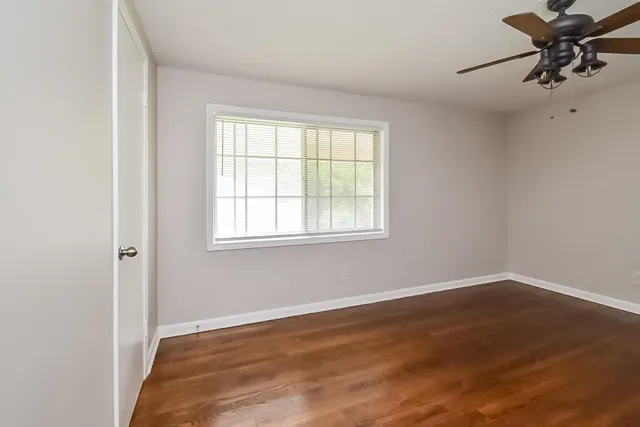 a view of a room with wooden floor and a window