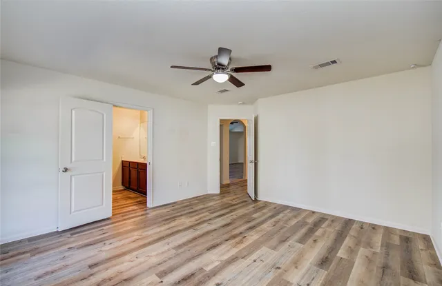 a view of a room with wooden floor and a ceiling fan