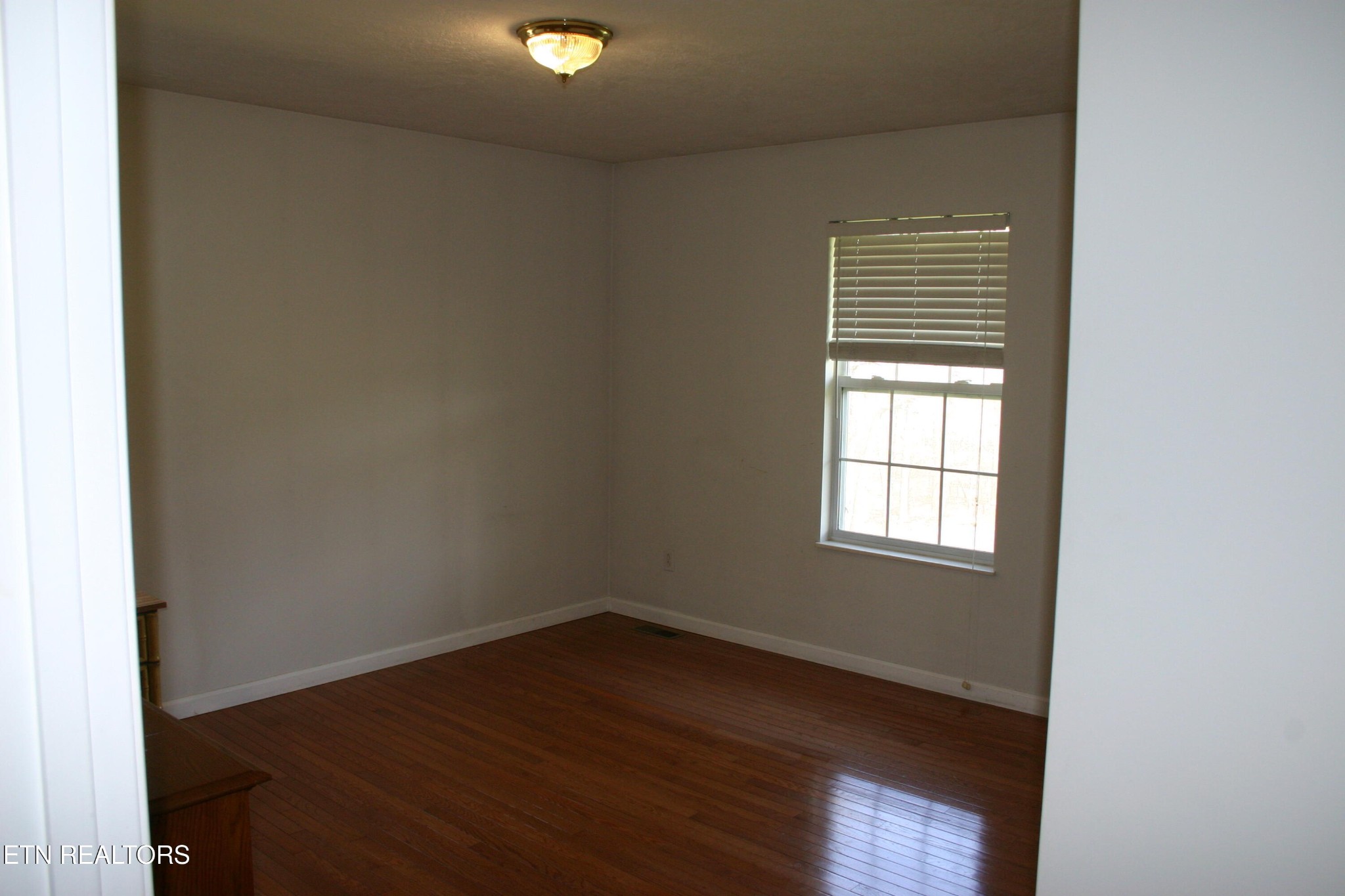 163 Upper Clear Creek Road Andersonville, TN 37705 - Photo 7 of 15 an empty room with wooden floor and windows