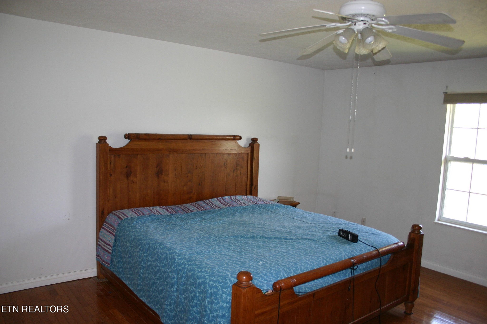 163 Upper Clear Creek Road Andersonville, TN 37705 - Photo 10 of 15 a bed sitting in a bedroom next to a window and chandelier
