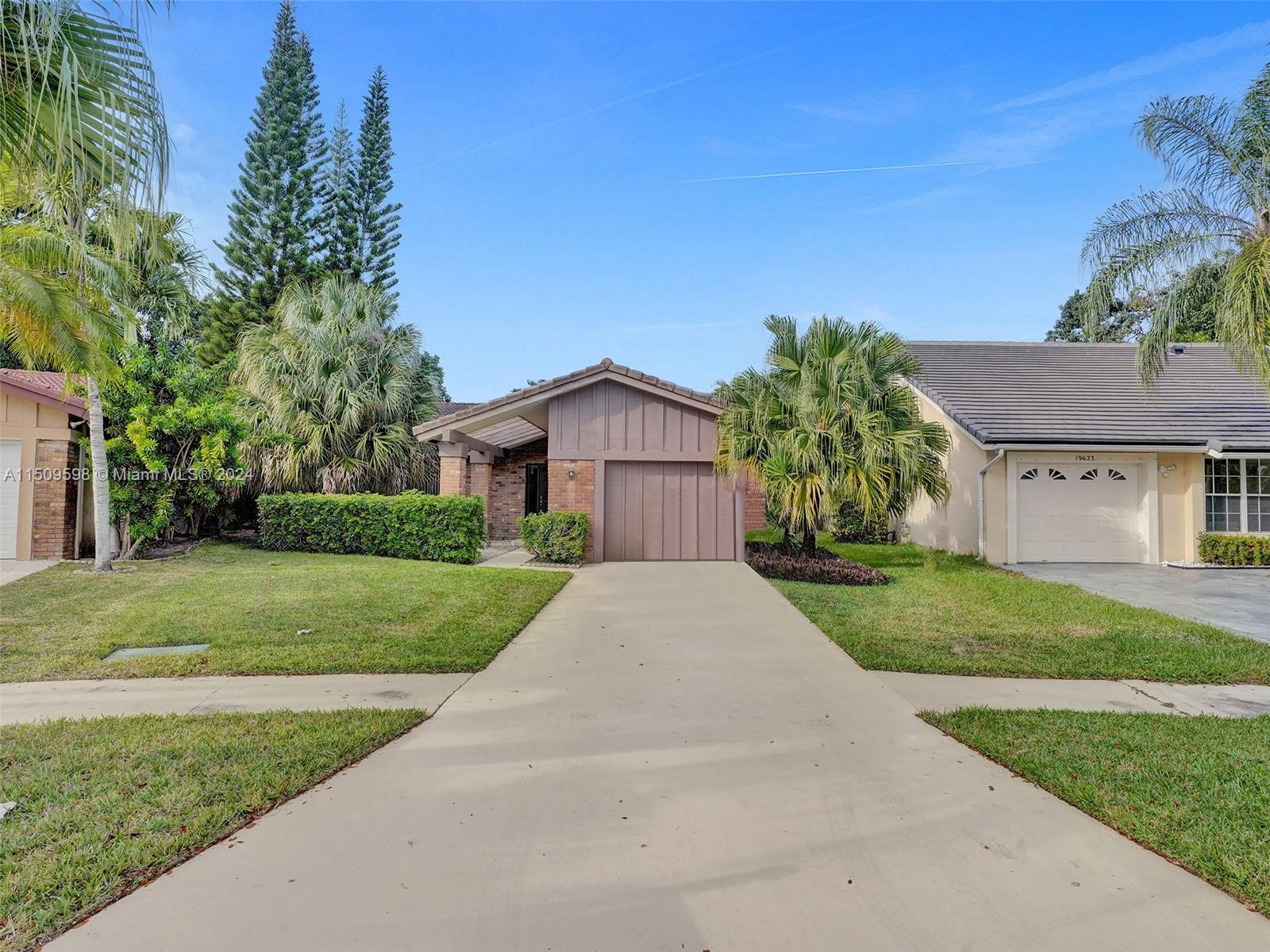 19621 Back 9 Drive Boca Raton, FL 33498 - Photo 1 of 45 a front view of a house with a yard and garage