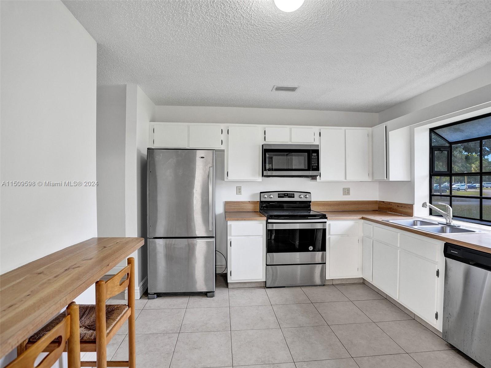 19621 Back 9 Drive Boca Raton, FL 33498 - Photo 16 of 45 a kitchen with a refrigerator stove and microwave