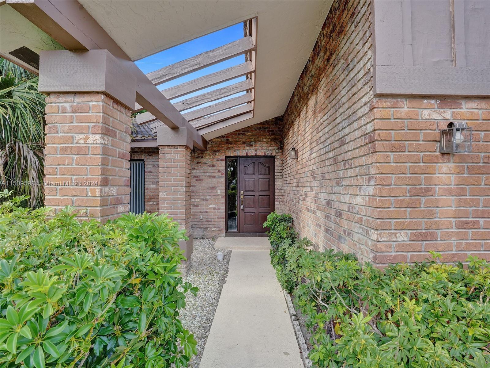19621 Back 9 Drive Boca Raton, FL 33498 - Photo 2 of 45 a pathway of a house with potted plants